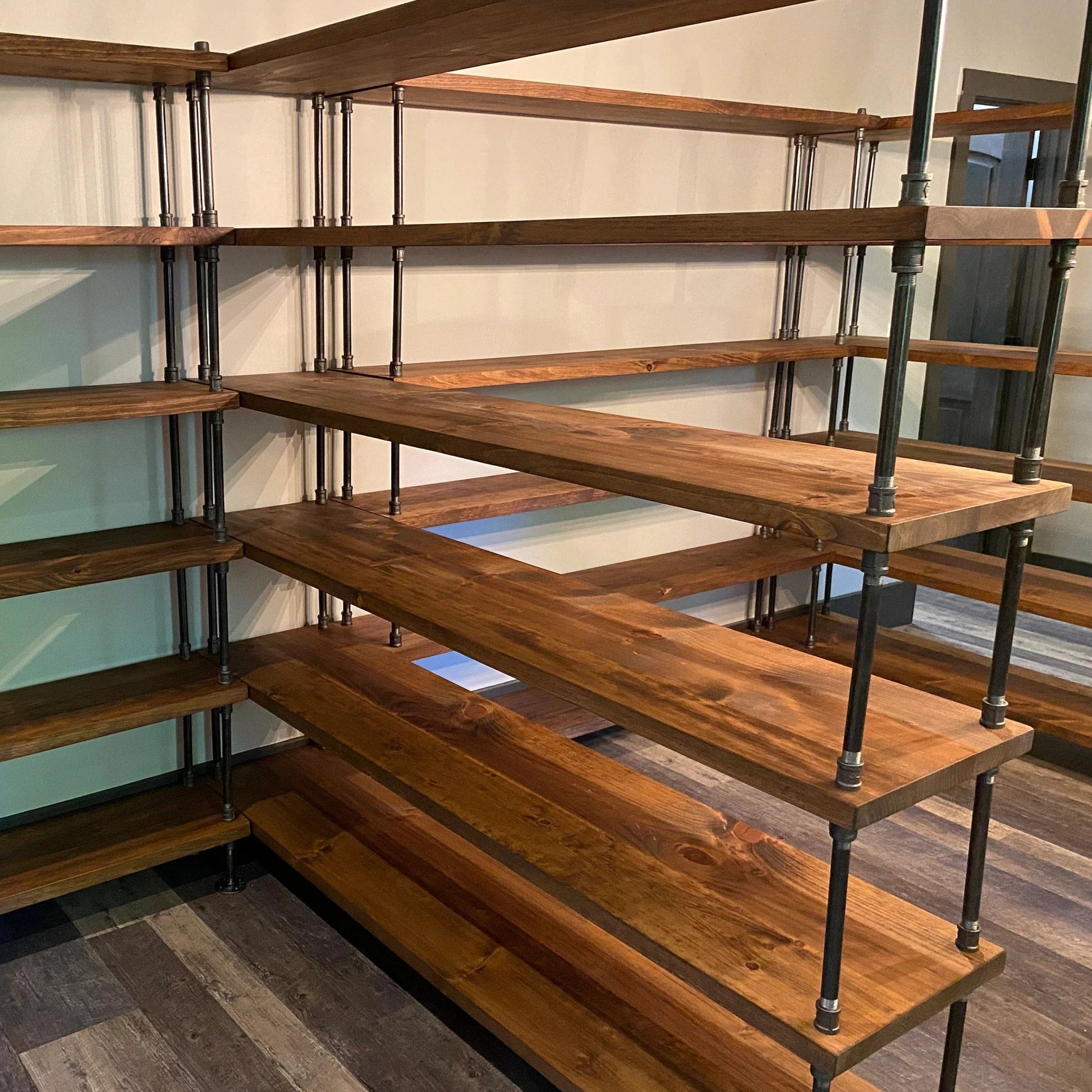 Handmade wood bookshelves with industrial iron pipe side rails, wood is sanded smooth and stained in warm brown honey stain. Shelving units are 72 inches long with 6 shelves high, ample storage for pantry or bookcase office storage.