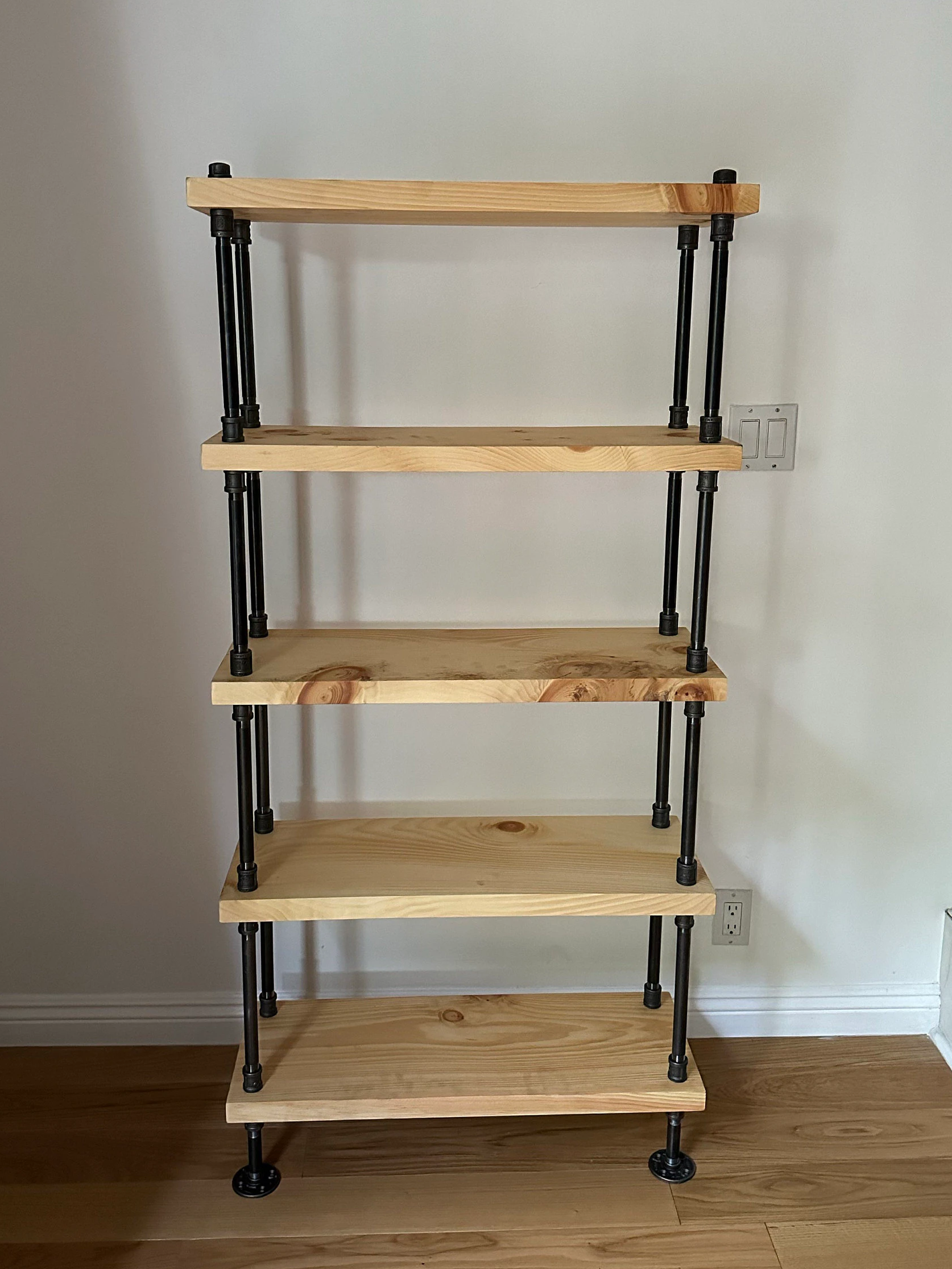 Wooden shelf with metal brackets against a plain wall.