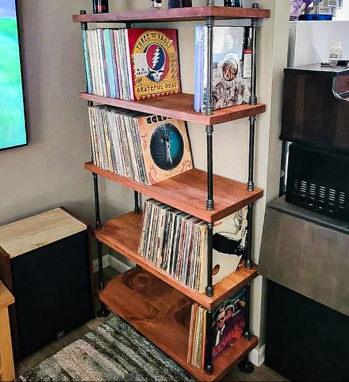 Wooden record player rack with vinyl records and a Grateful Dead album cover in a room setting.