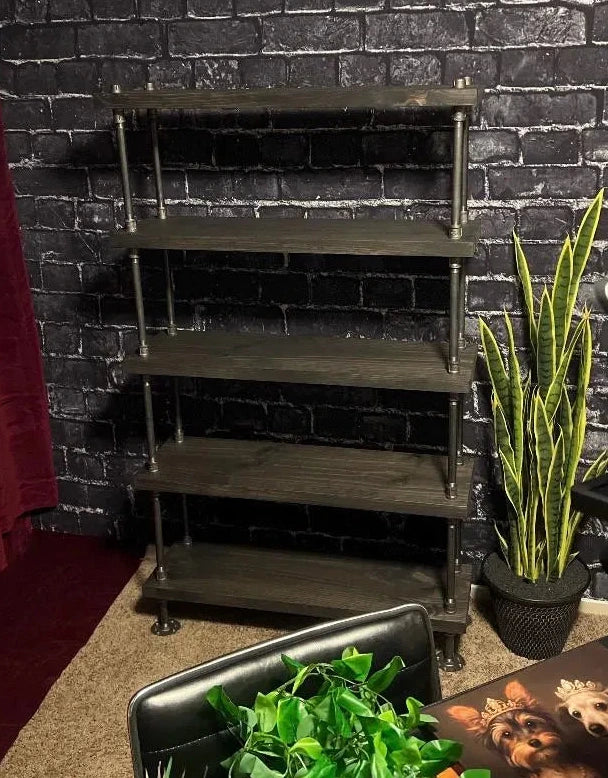 Wooden shelf against a black brick wall with plants and a red curtain.