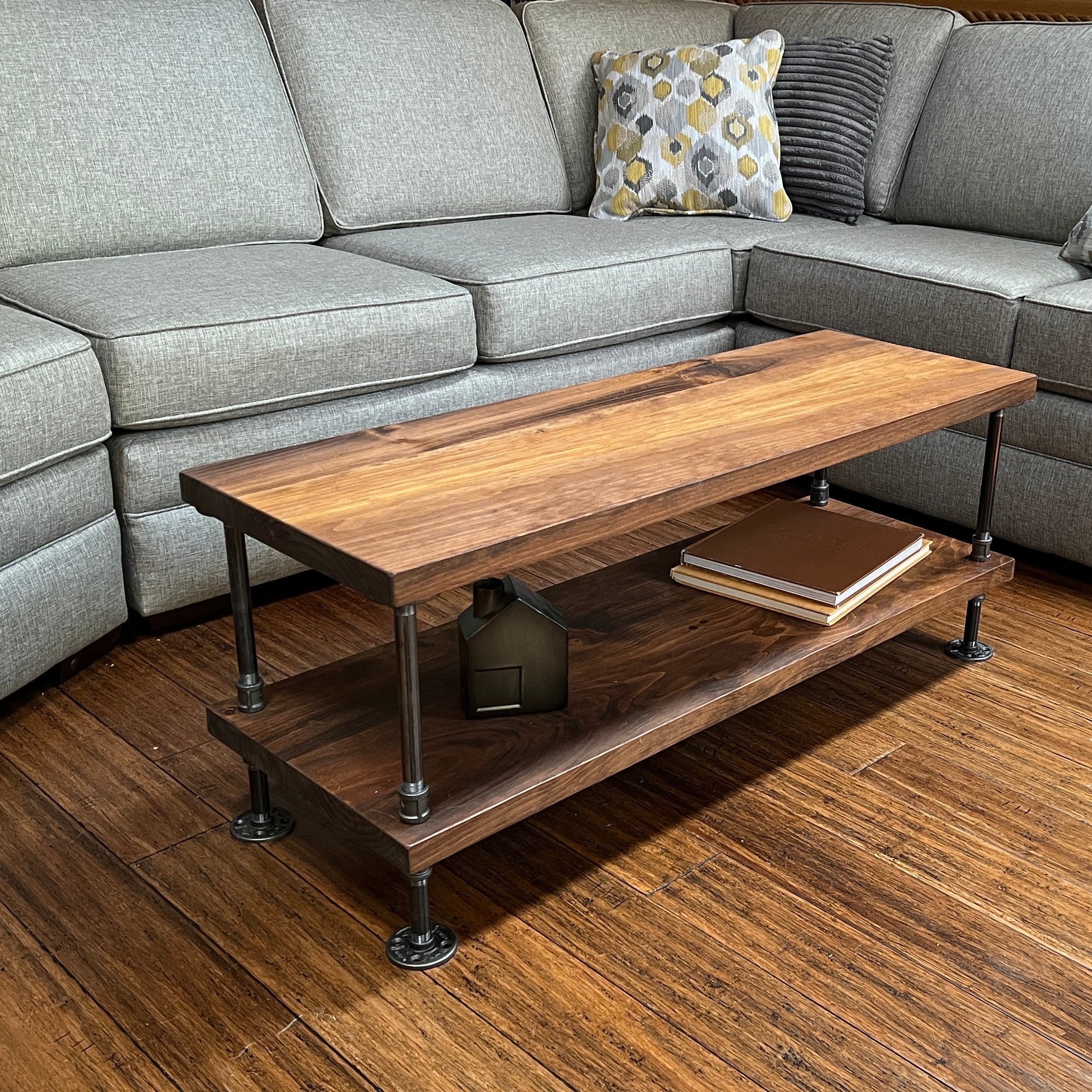 An industrial coffee table with a wooden top and metal frame, positioned in a living room setting.
