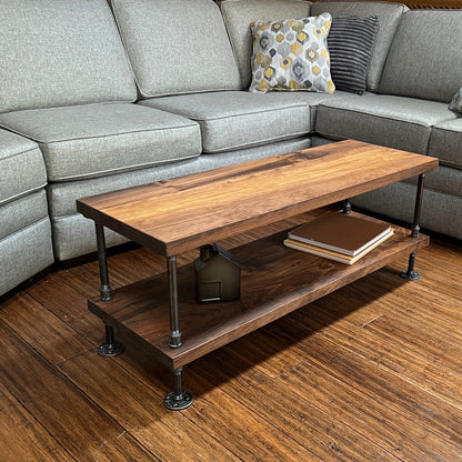 An industrial coffee table with a wooden top and metal frame, positioned in a living room setting.